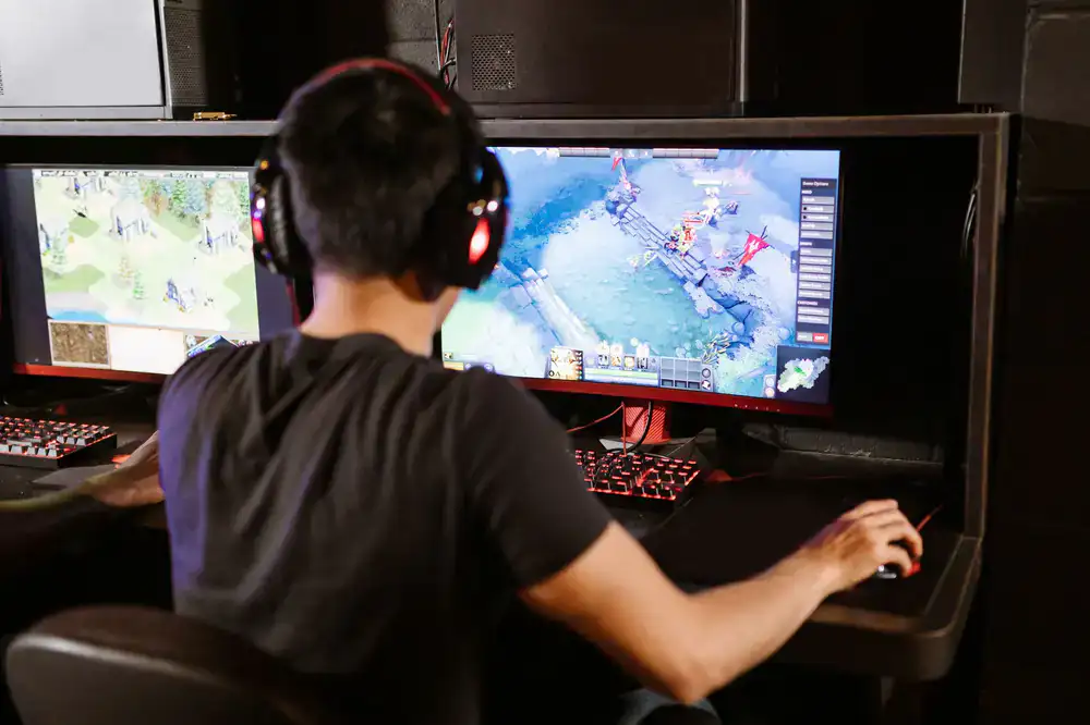 Localization linguist reviewing game dialogue on dual monitors